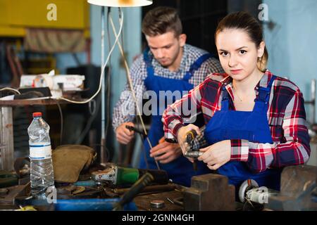 Porträt einer Arbeiterin, die in der Werkstatt einen verstellbaren Schraubenschlüssel hält. Stockfoto