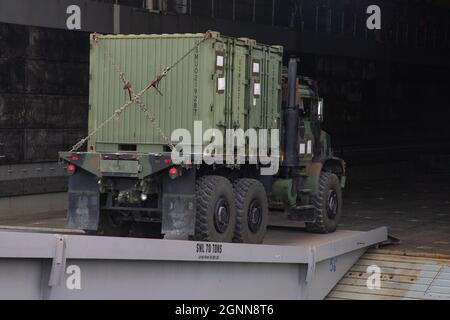 Ein mitteltaktischer Fahrzeugersatz des US Marine Corps tritt an Bord des amphibischen Transportschiffes USS Anchorage (LPD 23) auf dem Marinestützpunkt San Diego, Kalifornien, am 31. August 2021 in das Brunnendeck ein. Taktische Fahrzeuge und Ausrüstung werden in Vorbereitung auf die Übung UNITAS LXII verstaut. UNITAS ist die weltweit am längsten laufende jährliche multinationale maritime Übung, die sich auf die Verbesserung der Interoperabilität zwischen mehreren Nationen und gemeinsamen Kräften während pazifischer, amphibischer und amazon-Operationen konzentriert, um auf bestehenden regionalen Partnerschaften aufzubauen und neue dauerhafte Beziehungen zu schaffen, die Frieden, Stabilität, fördern Stockfoto