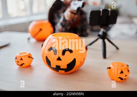 Hintergrundbild von Variationen Halloween Eimer mit Smartphone auf dem Tisch aufgestellt, Livestream Hintergrund Stockfoto