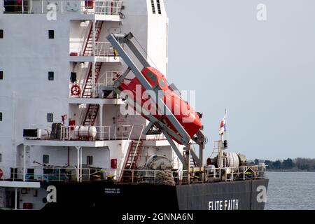 Charleston, SC - 24 2021. Februar: Ein großes orangefarbenes Rettungsboot, das sich vor dem Elite Faith Frachtschiff befindet Stockfoto