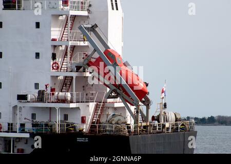 Charleston, SC - 24 2021. Februar: Ein großes orangefarbenes Rettungsboot, das sich vor dem Elite Faith Frachtschiff befindet Stockfoto