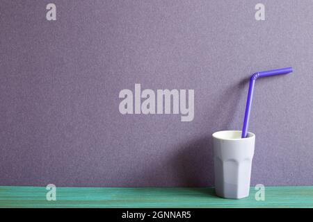 Lila Tasse auf grünen Holztisch. Lila Wand Hintergrund Stockfoto
