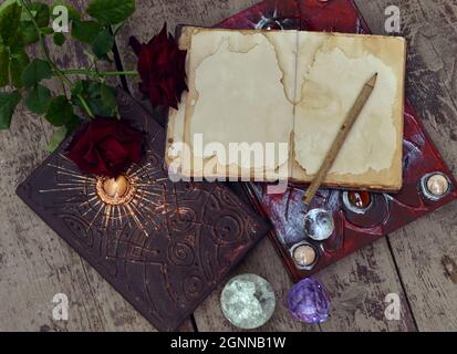 Stillleben mit altem offenen Buch, Kristall und Blumen. Wissenskonzept mit leerem Vintage-Tagebuch und Kopierraum, Draufsicht Stockfoto