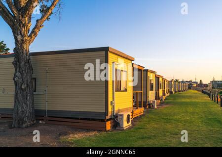 Moonta Bay, Südaustralien - 26. Oktober 2019: Moonta Bay Caravan Park Unterkunft Hütten in einer Reihe bei Sonnenuntergang, Südaustralien Stockfoto