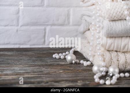 Stapel von weißen, kuscheligen Strickpullover auf Holztisch Stockfoto