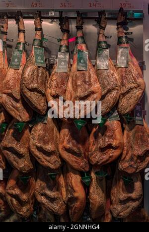 Mehrere ganze Knochen-Beine von spanischem serrano iberico Schinken hängen in einer Metzgerei in der Altstadt oder Casco Viejo in Pamplona, Spanien Stockfoto