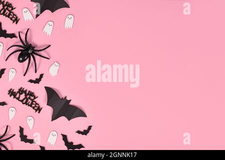 Halloween flach lag mit Fledermäusen, Spinnen, Happy Halloween Text und niedlichen Geistern auf Seite von rosa Hintergrund mit Kopierer Platz Stockfoto