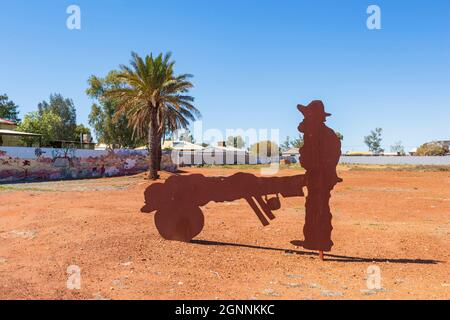 Metallkunstwerk eines alten goldminers, der in der kleinen ländlichen Stadt Cue, Region Murchison, Westaustralien, eine Schubkarre schiebt Stockfoto