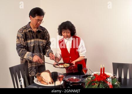 Asiatisch amerikanisches Paar dienen Weihnachten Abendessen Modell freigegeben Stockfoto