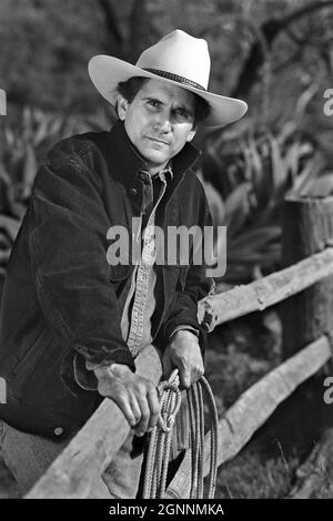 Ein Cowboy, der sich mit einem Lariat in Los Angeles, Kalifornien, an einen Zaun lehnte, WURDE FREIGELASSEN Stockfoto