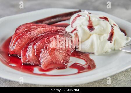 Weiße Schokoladenmousse mit Birnen in Rotwein auf Servierteller Stockfoto
