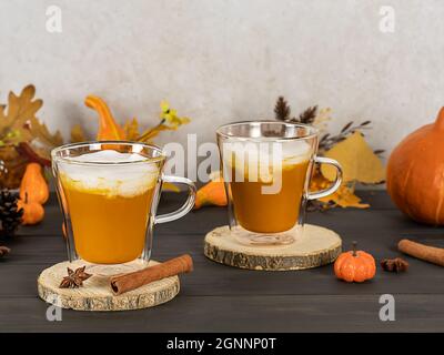 Kürbis-Gewürz-Latte in Glaskrügen mit Zimt, Muskatnuss und Schlagsahne. Stockfoto