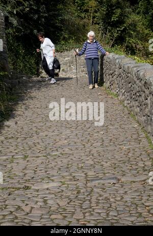 Zwei ältere Frauen gehen vorsichtig die gepflasterte Straße in Clovelly North Devon entlang Stockfoto