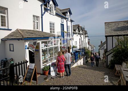 Besucher, die im alten Dorf Clovelly North Devon in einem Postfenster auf einer steilen Kopfsteinpflasterstraße blicken Stockfoto