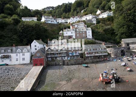 Abwechslungsreiche Häuser und Hütten im alten Dorf Clovelly, die bei Ebbe vom Hafen aus mit befahrenen Booten North Devon betrachtet werden Stockfoto