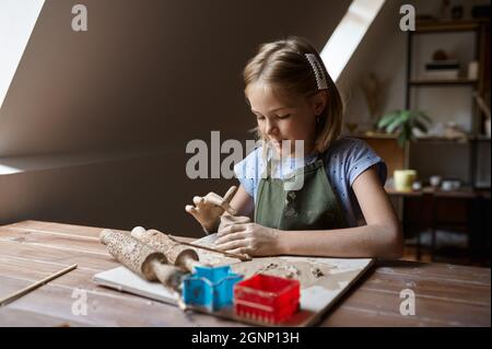 Kleines Mädchen arbeitet mit Ton, Kind in der Werkstatt Stockfoto