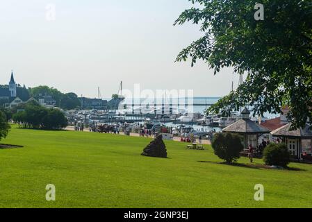 Mackinaw Island, MI - 14. Juli 2021: Pferd und Buggy mit Yachthafen auf Mackinaw Island MI am 14. Juli 2021. Stockfoto