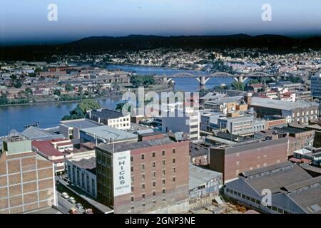 Ein Blick vom Rathaus nach Westen über Brisbane und den Brisbane River, Queensland, Australien im Jahr 1966 – ein bedrohlicher Himmel steht am Horizont. Geschäfte entlang der George Street sind sichtbar (von links nach rechts), einschließlich Woolworths. Die William Jolly Bridge aus den 1930er Jahren im Art déco-Stil überquert den Fluss, der 1955 in Erinnerung an William Jolly, den ersten Oberbürgermeister des Großraums Brisbane, benannt wurde. Brisbane ist die größte Stadt und Hauptstadt von Queensland. Dieses Bild stammt von einem alten Kodak-Amateurfotograf mit Farbtransparenz – einem alten Foto aus den 1960er Jahren. Stockfoto