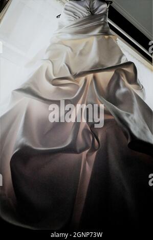 Aufnahme eines eleganten weißen Brautkleides, das an einem Kleiderbügel hängt Stockfoto