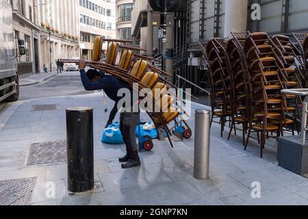 Nach einer Veranstaltung in Lloyds of London in der City of London, dem Finanzdistrikt der Hauptstadt, am 24. September 2021 in London, England, beladen Auftragnehmer des Möbelherstellers „Well dressed Tables“ hohe Stapel von Veranstaltungsstühlen in den Lastwagen des Unternehmens. Stockfoto