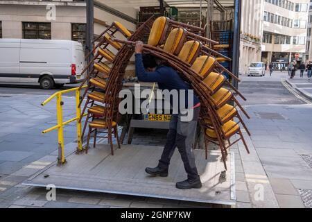 Nach einer Veranstaltung in Lloyds of London in der City of London, dem Finanzdistrikt der Hauptstadt, am 24. September 2021 in London, England, beladen Auftragnehmer des Möbelherstellers „Well dressed Tables“ hohe Stapel von Veranstaltungsstühlen in den Lastwagen des Unternehmens. Stockfoto