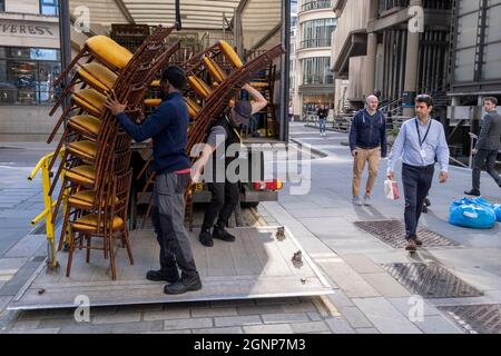 Nach einer Veranstaltung in Lloyds of London in der City of London, dem Finanzdistrikt der Hauptstadt, am 24. September 2021 in London, England, beladen Auftragnehmer des Möbelherstellers „Well dressed Tables“ hohe Stapel von Veranstaltungsstühlen in den Lastwagen des Unternehmens. Stockfoto