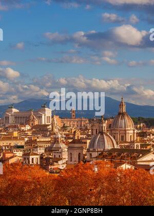 Herbst in Rom. Blick auf die Skyline des historischen Zentrums kurz vor Sonnenuntergang mit alten Denkmälern, barocken Kuppeln und roten Blättern Stockfoto