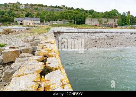 Der alte Kai in Penmon, Anglesey, an der Menai-Straße, aus Kalkstein aus dem Steinbruch hergestellt, um den gleichen Kalkstein im ganzen Land zu transportieren. Stockfoto