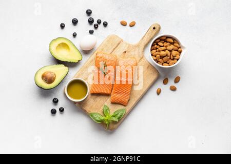 Ein Stück roter Fisch auf einem Holzbrett. Eine Auswahl an nützlichen Proteinquellen und Produkten zur Stärkung des Körpers. Keto-Diät. Stockfoto