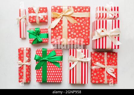 Viele Weihnachtsgeschenkschachteln in farbigem Papier auf dem Tisch dekoriert, Draufsicht aus der Nähe. Viele präsentieren Neujahrsgeschenk. Stockfoto