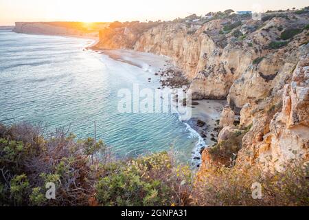 Atemberaubende Aussicht über Praia do Camilo in Lagos, Algarve Portugal während des Sonnenaufgangs. Felsen, Klippen und Formationen im Meer. Ein Naturschatz Stockfoto