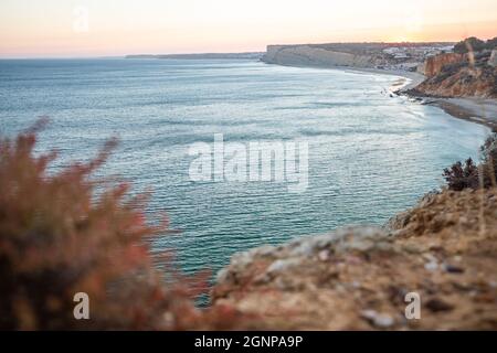 Atemberaubende Aussicht über Praia do Camilo in Lagos, Algarve Portugal während des Sonnenaufgangs. Felsen, Klippen und Formationen im Meer. Ein Naturschatz Stockfoto