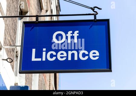 Off License oder Spirituosengeschäft blaues Werbenlogo vor dem Eingang zu einem Alkoholgeschäft, das Bier und Wein verkauft, Stock Photo im Stockfoto