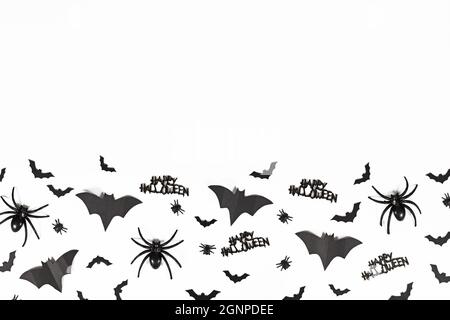Schwarze Halloween Fledermäuse, Spinnen, Fliegen und Happy Halloween Text unten auf weißem Hintergrund mit Kopierraum Stockfoto