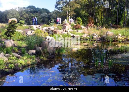 Menschen am Teich im chinesischen Streamside Garden im RHS Garden Bridgewater, Worsley, Manchester, Großbritannien. Stockfoto