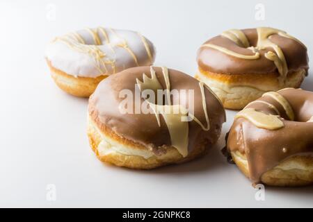 Glasierte Donuts mit Schokolade, Vanille und Karamell-Zuckerguss - rustikaler Stil köstlicher Donut-Hintergrund mit Kopierfläche Stockfoto