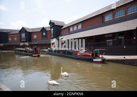 Narrowboats auf Banbury Lock, die am Castle Quay Shopping Centre in North Oxfordshire in Großbritannien vorbeifahren, aufgenommen am 26. Juni 2020 Stockfoto