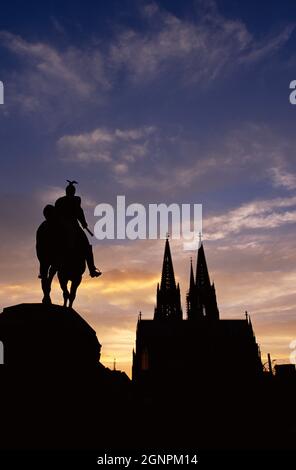 Deutschland. Köln. Kathedrale und Kaiser Wilhelm II. Reiterstatue Silhouetten bei Sonnenuntergang. Stockfoto