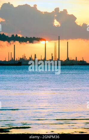 Singapur. Branche. Pulau Anak Bukom. Ölraffinerie am Wasser bei Sonnenuntergang. Stockfoto