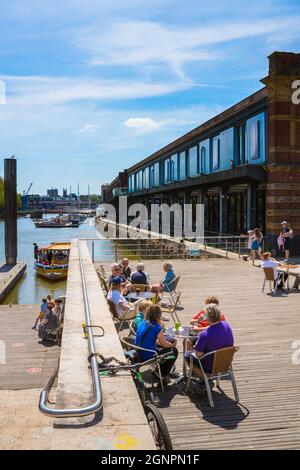 Bristol Waterfront, Blick im Sommer auf Menschen, die sich auf einer Cafeterrasse neben der City Center Landing im Hafenviertel, Bristol England, entspannen Stockfoto