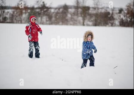 Brüder am Wintertag. Wandern im Park an kalten Tagen mit Schnee und Schneefall. Stockfoto