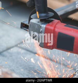 Arbeiten mit einer Kreissäge, um Metall aus nächster Nähe zu schneiden Stockfoto