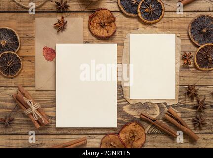 Winter Weihnachten Komposition mit einer leeren Karten und Umschlag über Holztisch flach legen. Weihnachten und Neujahr Grußkartenvorlage mit getrockneten Früchten Stockfoto