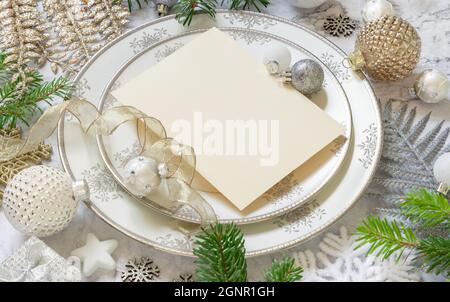 Festliche Tischkulisse mit Ornamenten und Tannenzweigen. Nachbau der Einladungskarte zu Weihnachten oder Neujahr auf weißem Marmortisch, Platz zum Kopieren. Winter Stockfoto