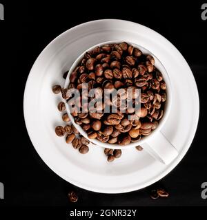 Tasse mit Kaffeebohnen. Kaffeebohnen auf schwarzem Hintergrund. Hochwertige Fotos Stockfoto