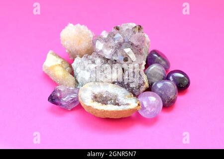 Wunderschöne Edelsteine, Geode aus Amethyst und Druse aus natürlichem purpurnen Mineral Amethyst auf einem leuchtend rosa Hintergrund. Amethysten und Rosenquarz. Großes c Stockfoto