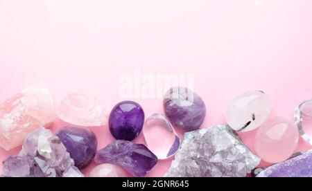 Wunderschöne Edelsteine und Druse aus natürlichem purpurfarbenem Amethyst auf einem rosa Hintergrund. Amethysten und Rosenquarz. Große Kristalle aus semi-kostbarem sto Stockfoto