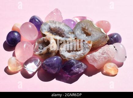 Wunderschöne Edelsteine, Geode Amethyst und Druse aus natürlichem purpurnen Mineral Amethyst auf einem rosa Hintergrund. Amethysten und Rosenquarz. Große Kristalle von Stockfoto