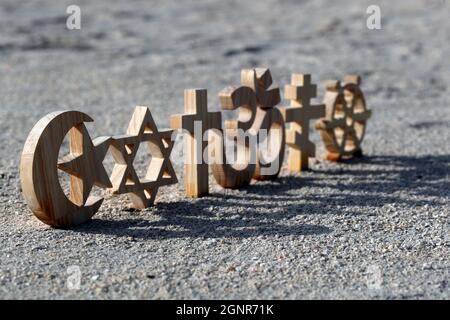 Religiöse Symbole auf Sand. Christentum, Islam, Judentum, Orthodoxie-Buddhismus und Hinduismus. Interreligiöses oder interreligiöses Konzept. Stockfoto