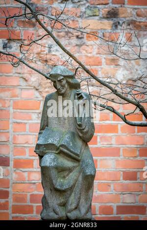 VILNIUS, LITAUEN - 2020. MÄRZ 06. Vaclovas Krutinis Skulptur, die einen sitzenden Mann mit einem offenen Buch auf den Knien zeigt. Stockfoto